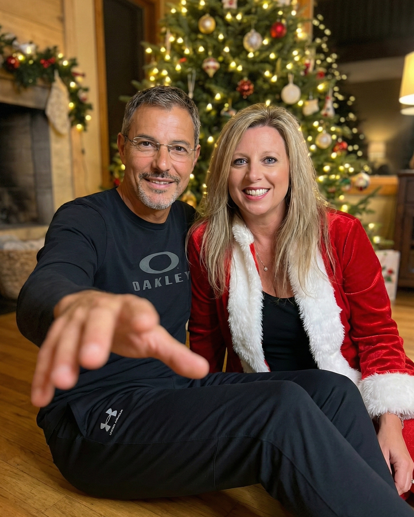 Playful Christmas portrait of Joey Montes reaching forward and Heather Killebrew smiling in a Santa suit.