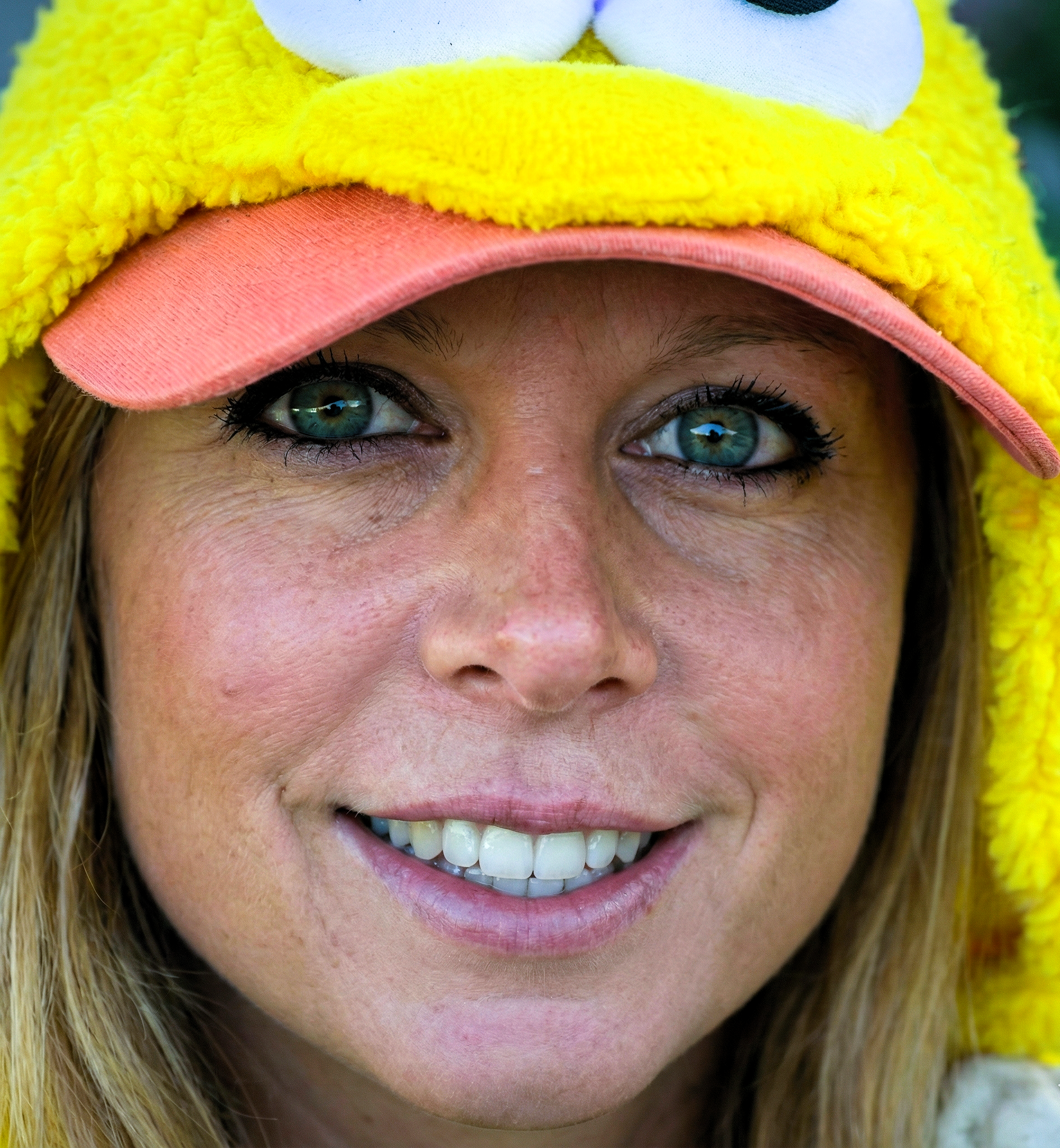 Close-up of Heather Killebrew smiling while wearing a fuzzy yellow bird costume hood.