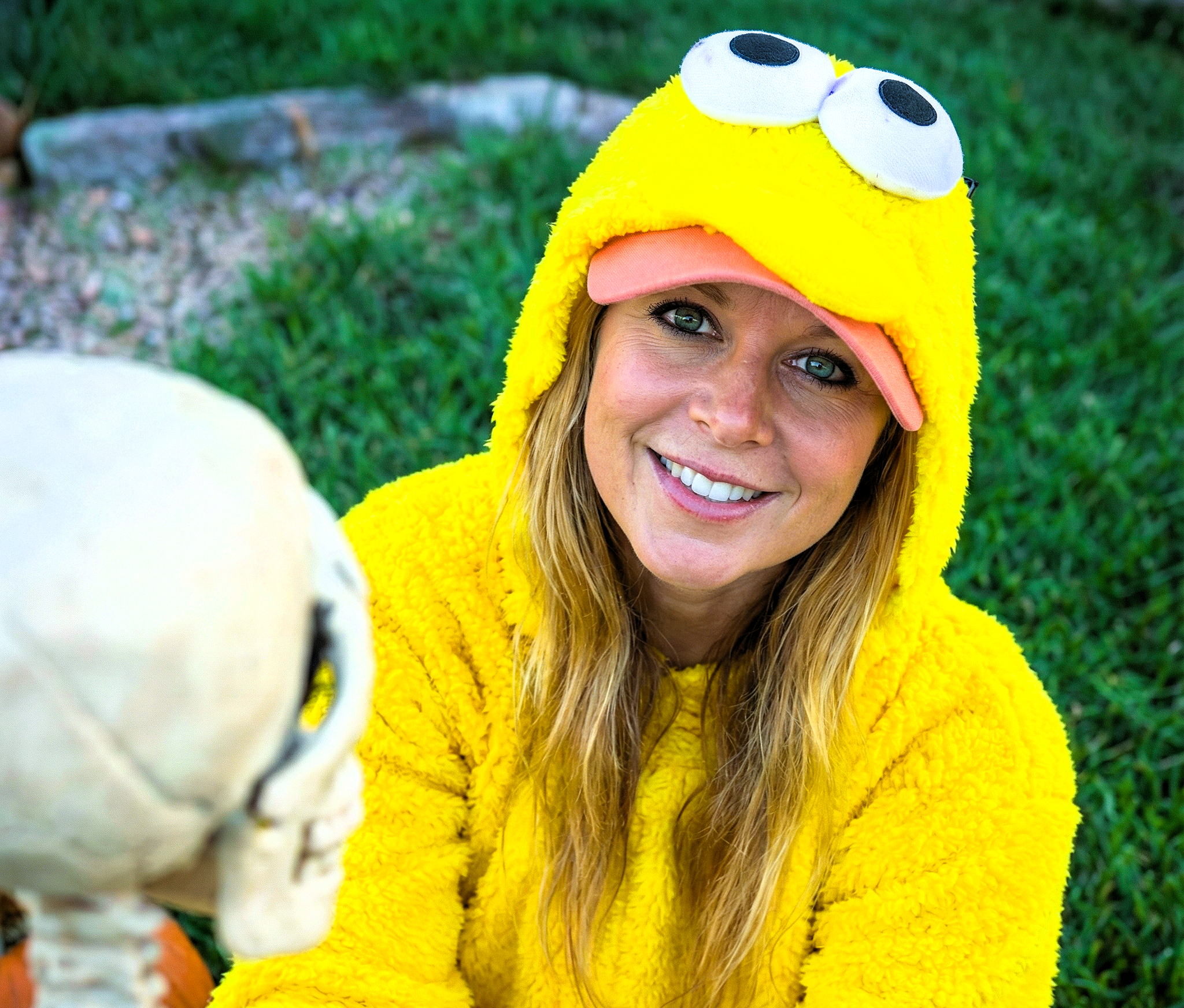 Close-up portrait of Heather Killebrew in a yellow hood smiling directly at the camera.