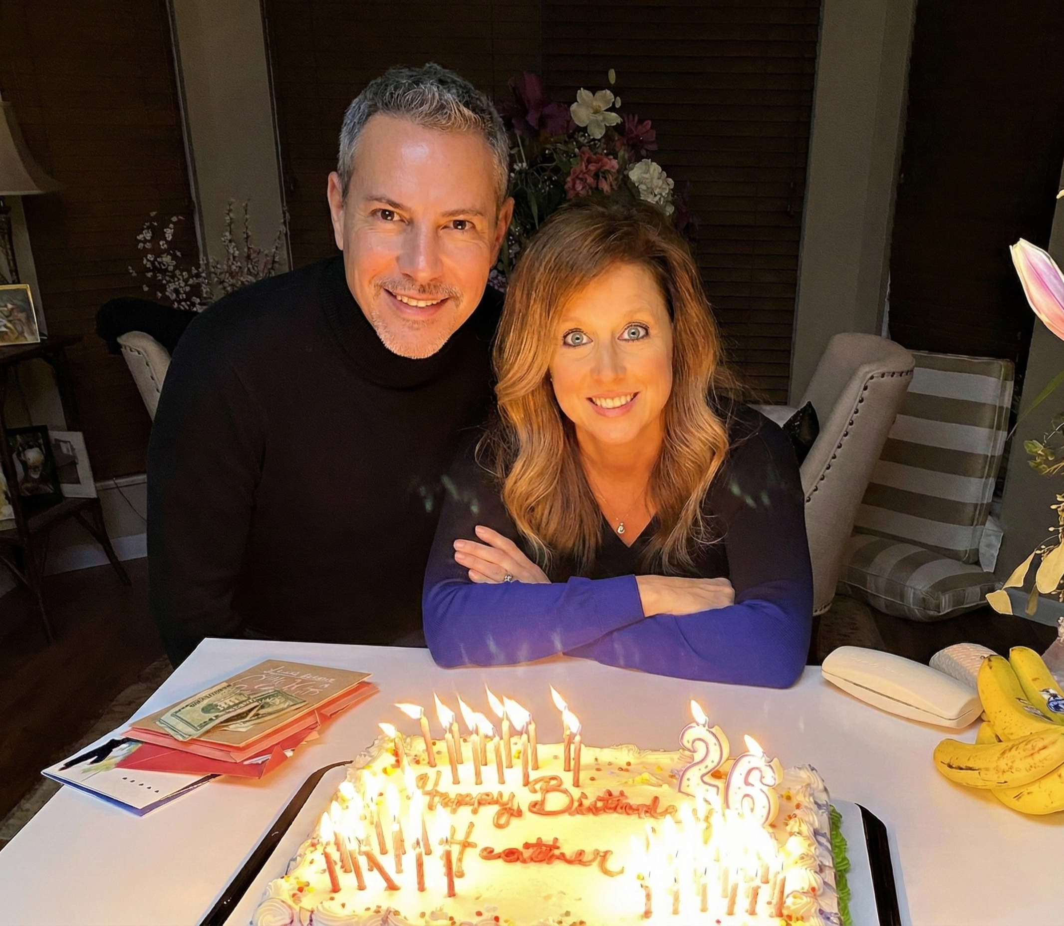 Joey Montes and Heather smiling behind a lit birthday cake with candles that say 26 in Wildwood on Feb 26, 2020.