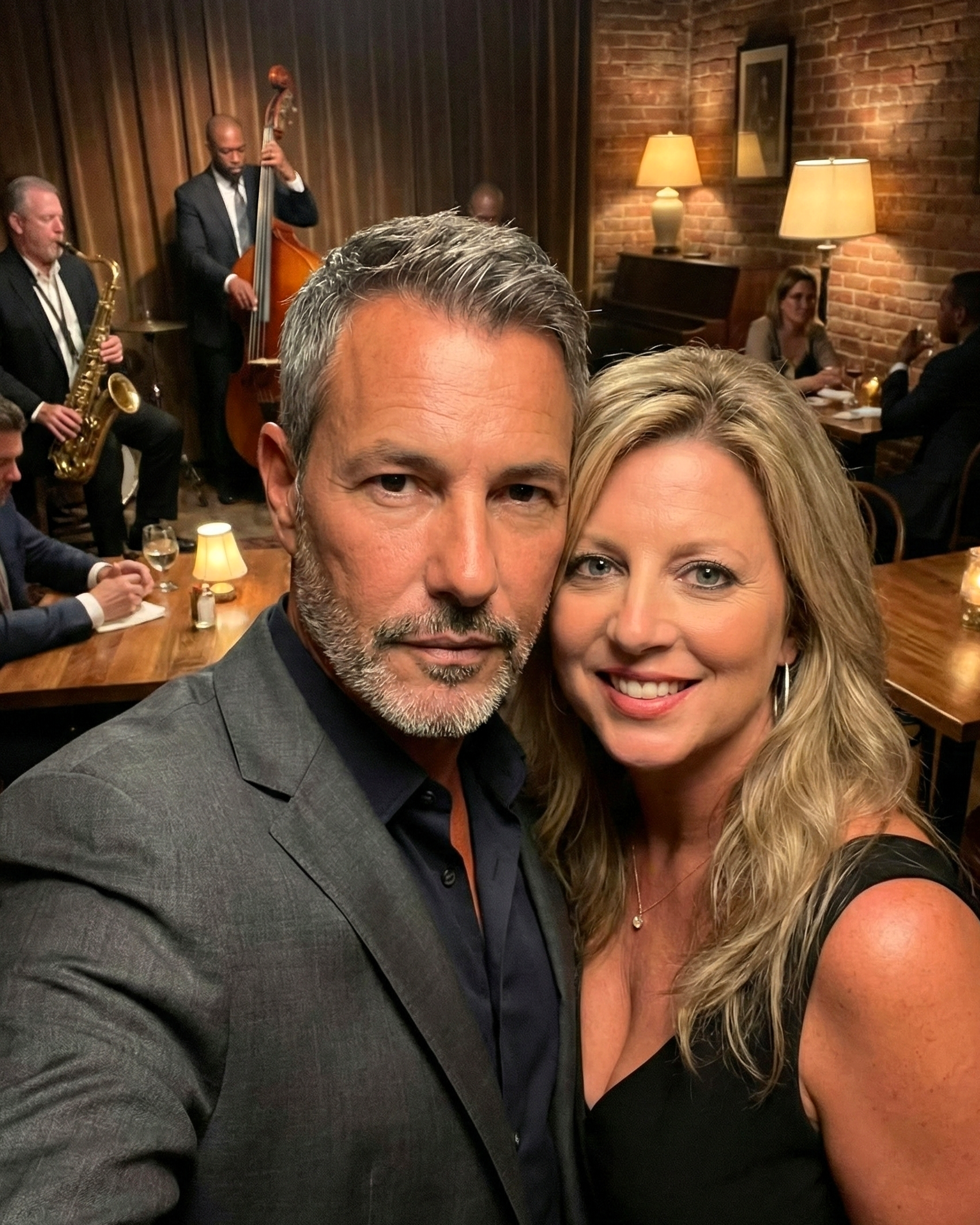 Selfie of Joey Montes and Heather Killebrew enjoying a relaxed evening at a jazz club with musicians playing in the background.