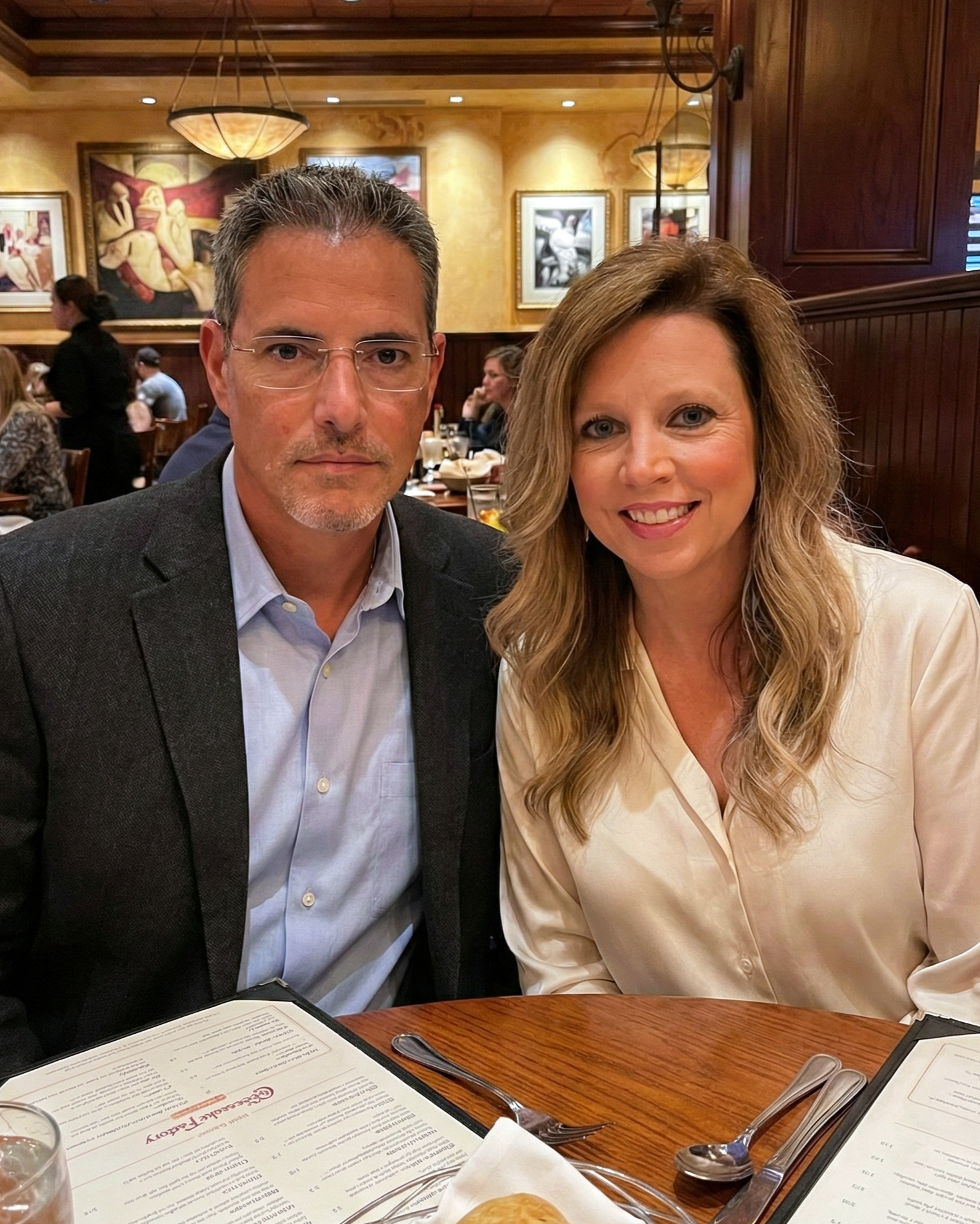 Joey Montes and Heather Killebrew sitting at a table with menus at The Cheesecake Factory in Chesterfield, MO.