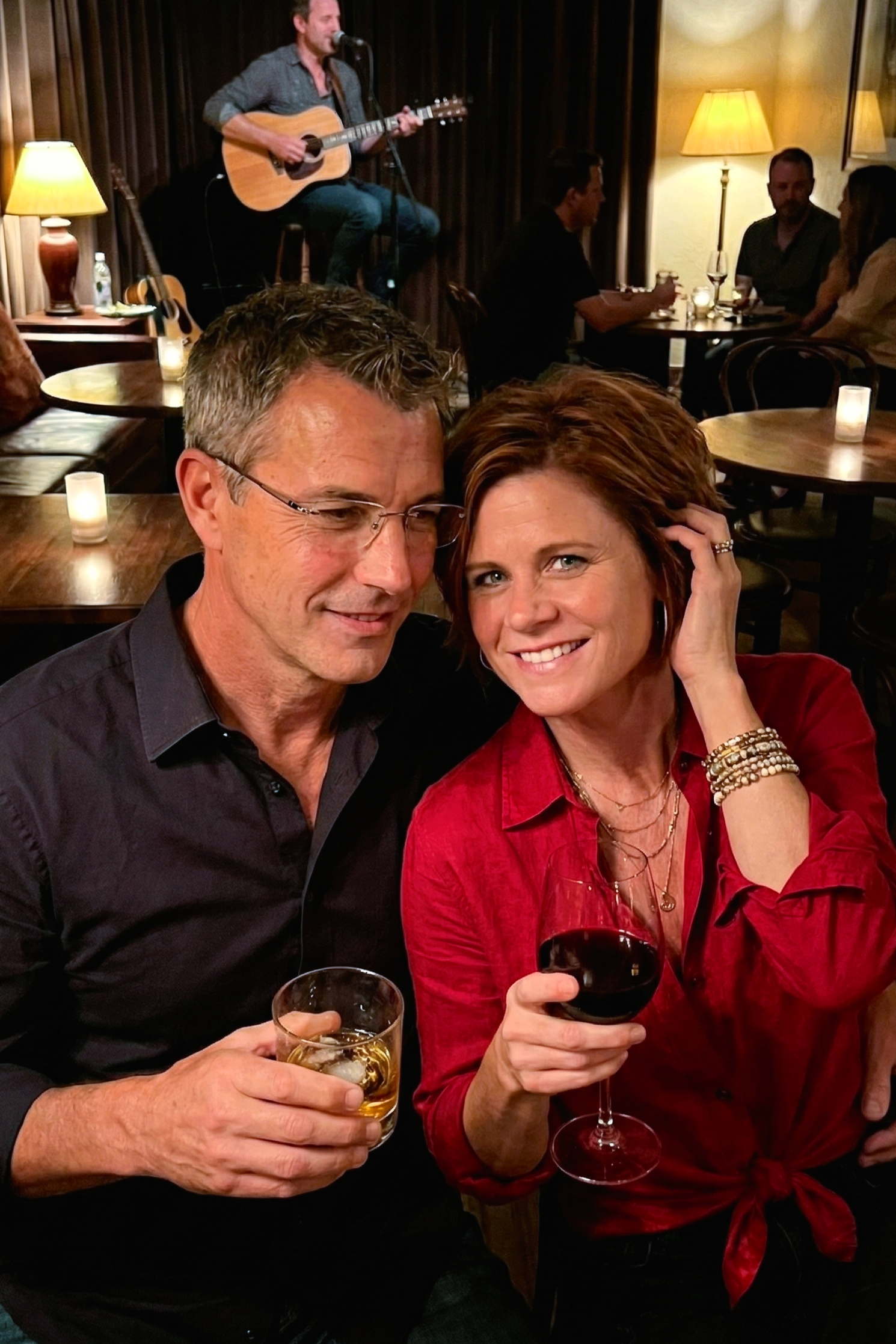 Romantic shot of Joey Montes looking at Dawne while enjoying drinks and live acoustic music.