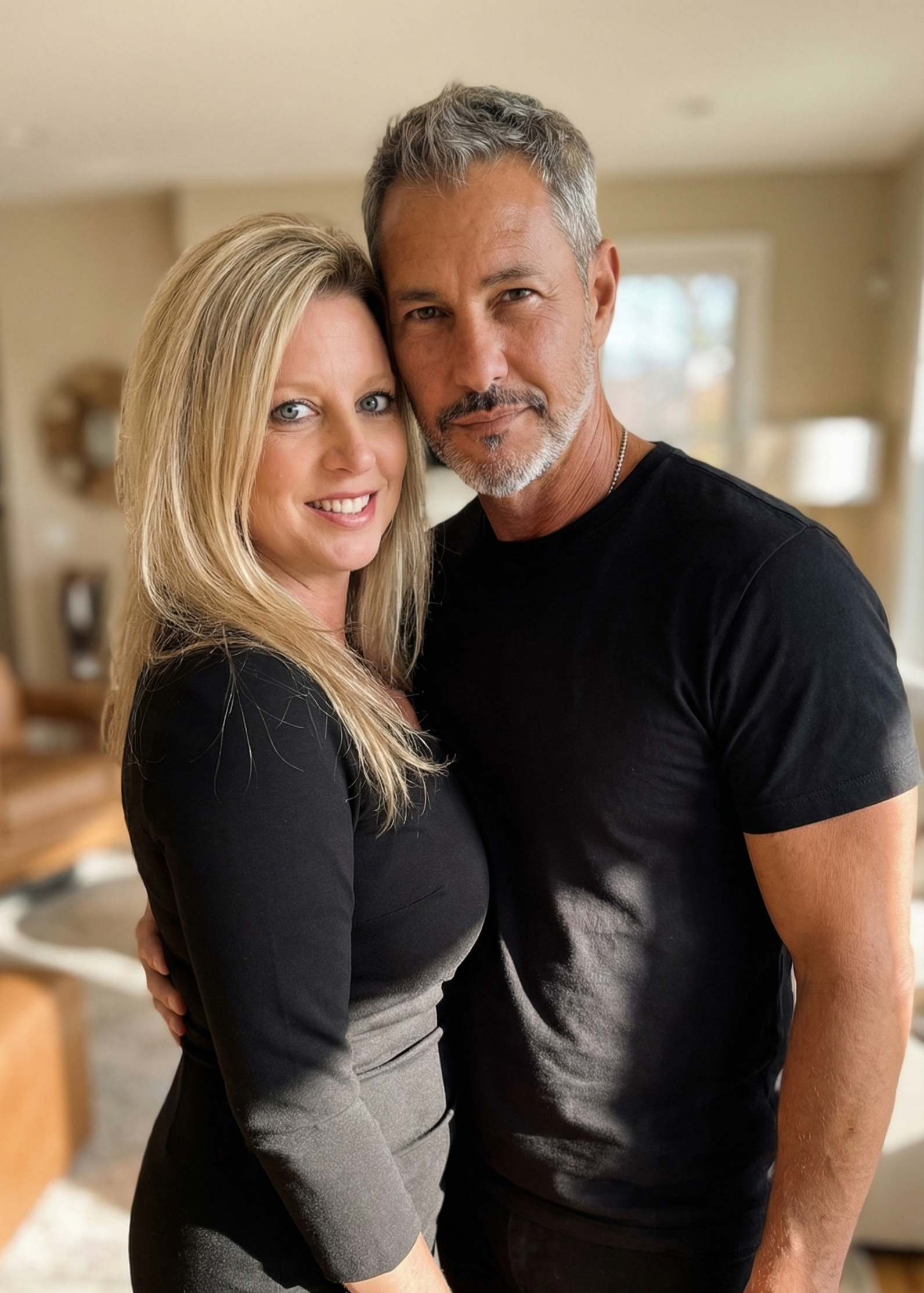 Heather Killebrew and her companion wearing black shirts in a sunlit home portrait.